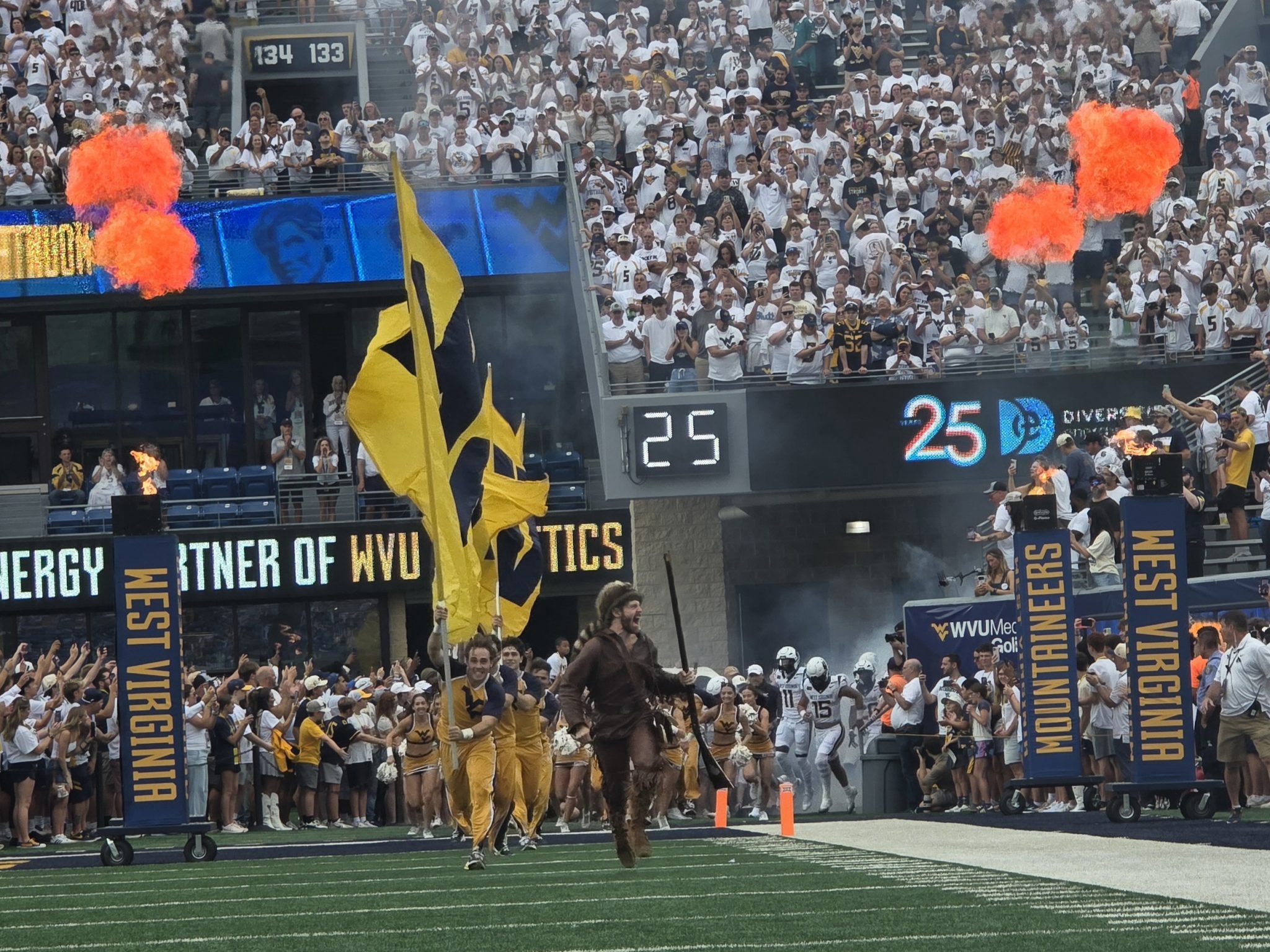 WVU Football mascot running on field with flag